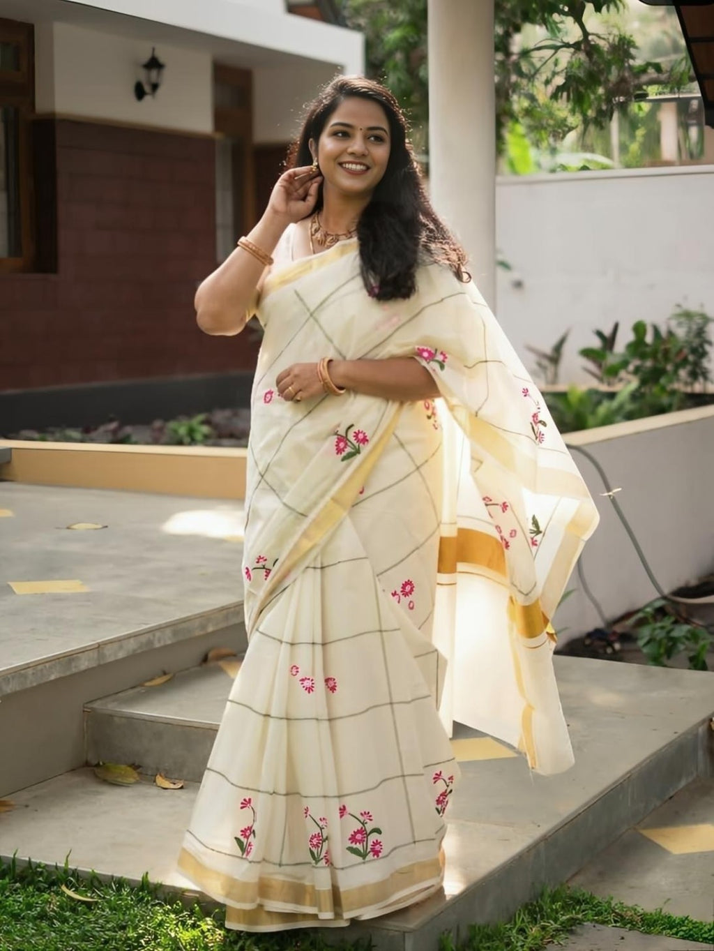 Full-length cream saree with floral details and gold border