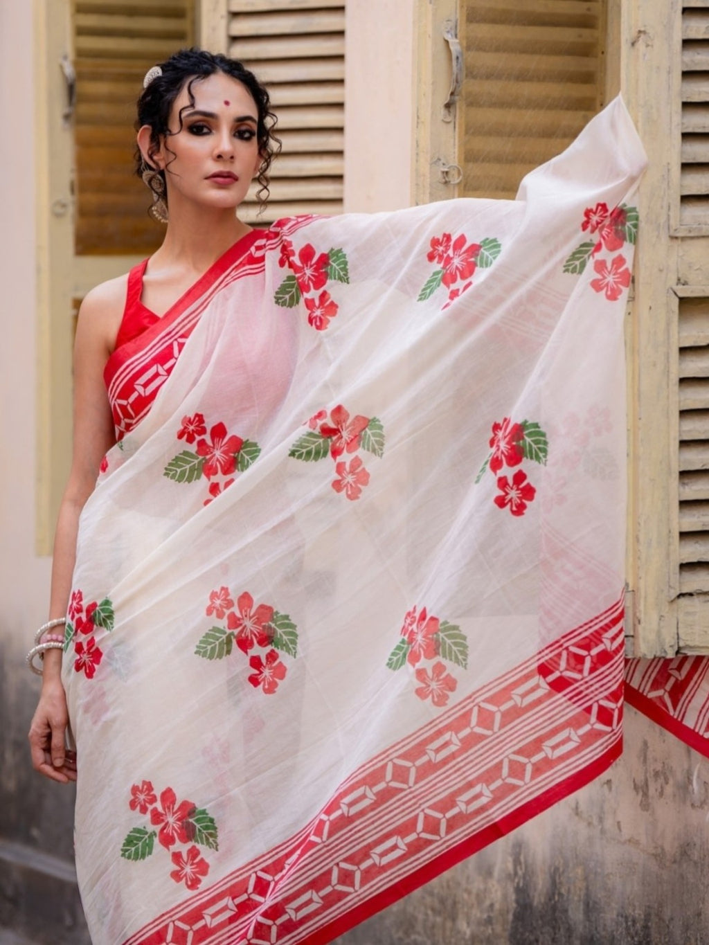 Full view of white saree with red floral print and patterned border