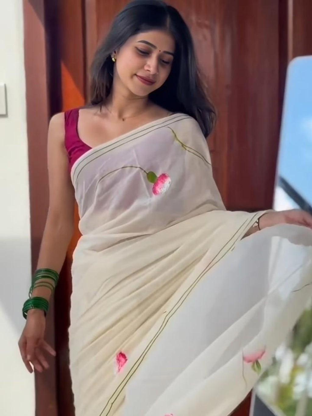 Model wearing ivory saree with pink floral bud print and green border