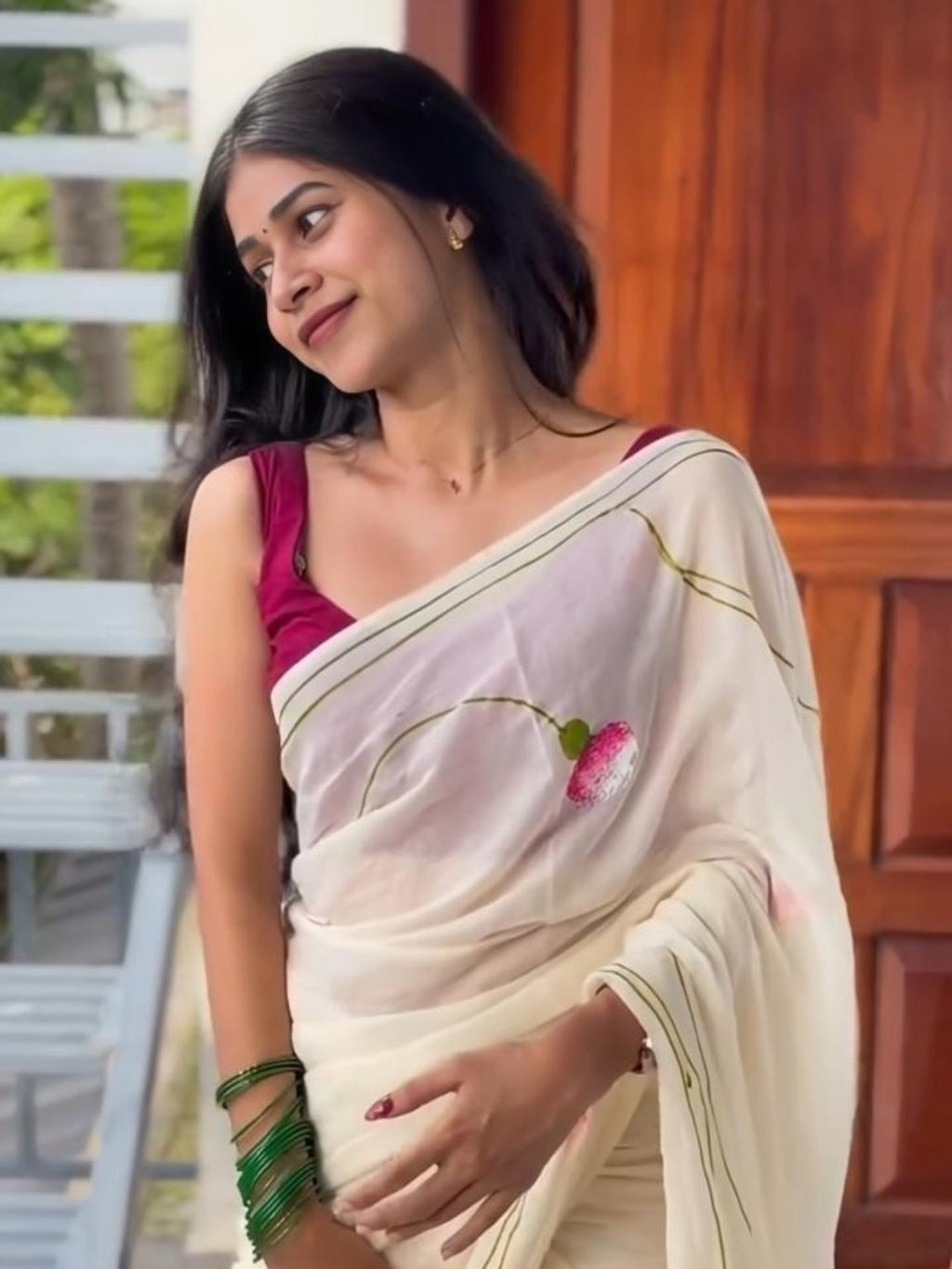 Model wearing cream ivory linen saree with pink floral buds and green border